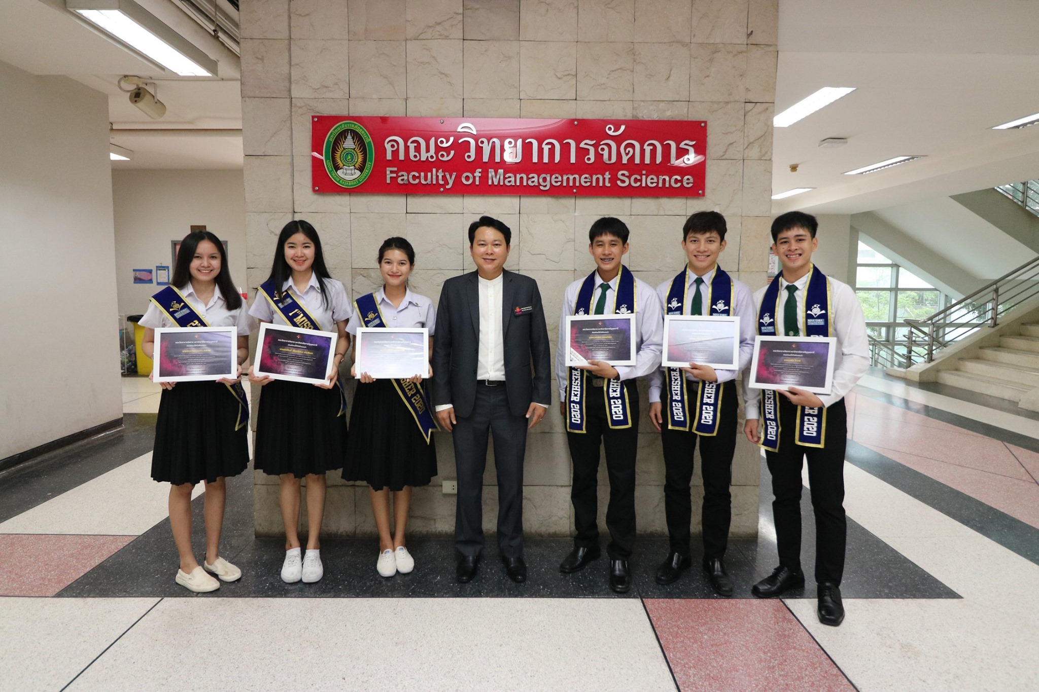 ผู้ช่วยศาสตราจารย์ ดร.พนา ดุลยพัชร์ คณบดีคณะวิทยาการจัดการ มหาวิทยาลัยราชภัฏอุดรธานี มอบเกียรติบัตรแสดงความยินดีกับขวัญใจน้องใหม่ (ดาว-เดือน) คณะวิทยาการจัดการ ปีการศึกษา 2563